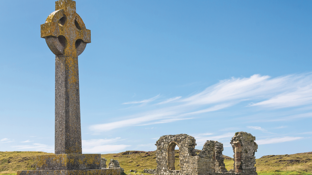A Celtic cross and St. Dwynwen’s Church ruins on Ynys Llanddwyn island.